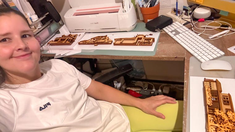 Hand-painting the details of a wooden house replica
